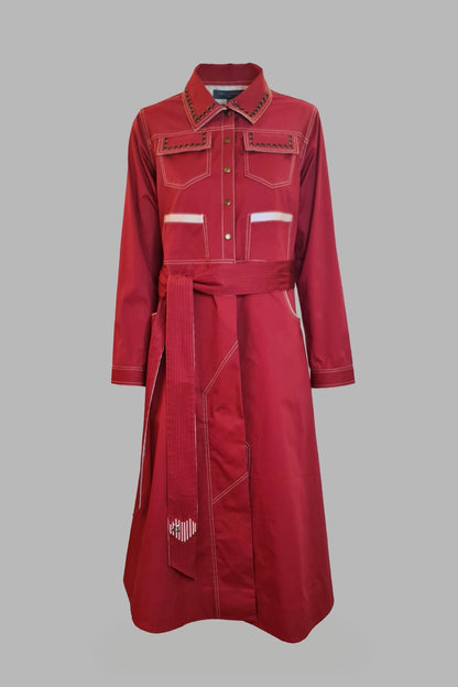 A burgundy trench coat with a collared neckline, button-up front, and decorative detailing on the shoulders and sleeves.