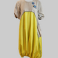 Balloon dress with a beige top and yellow bottom on a white background