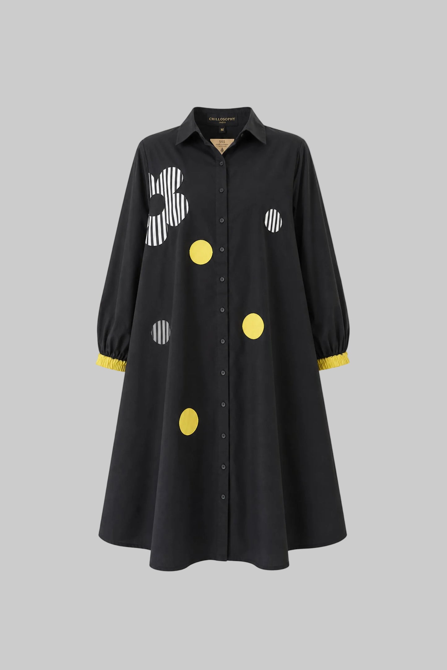 Black dress with colorful polka dot patterns on a gray background