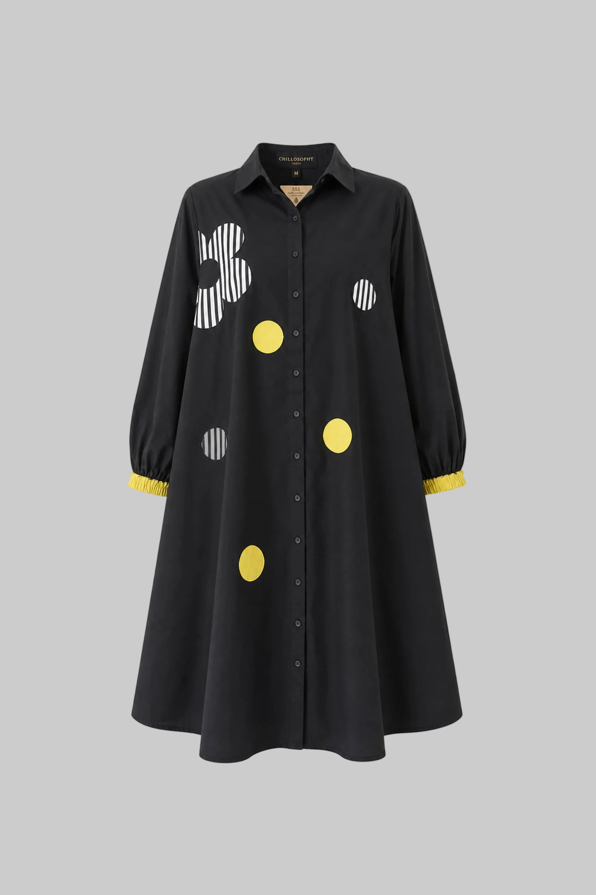 Black dress with colorful polka dot patterns on a gray background