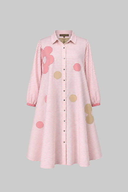 Pink striped dress with floral and polka dot patches on a gray background