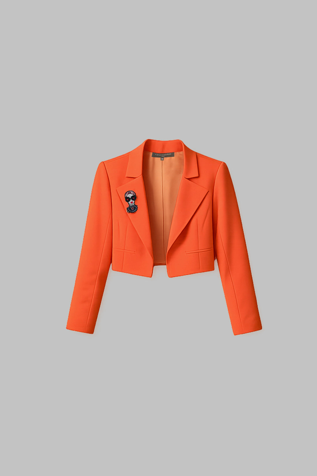 Orange blazer with a patch on a gray background