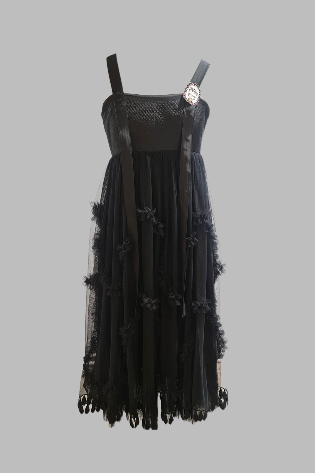 Black dress with sheer overlay on a gray background