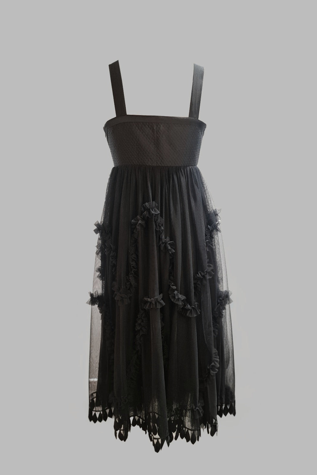 Black dress with floral details on a gray background