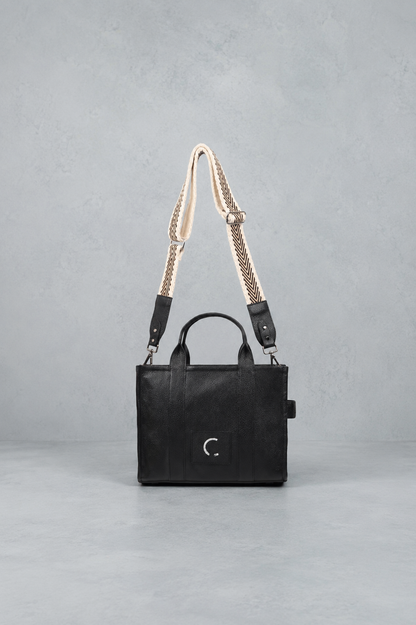 Black handbag with a chain strap on a gray background
