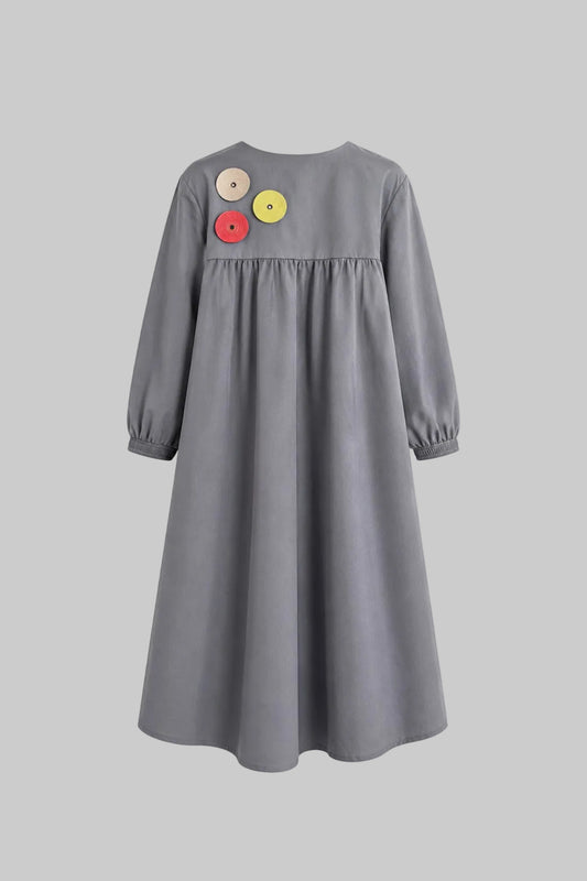 Gray dress with colorful buttons on a light gray background