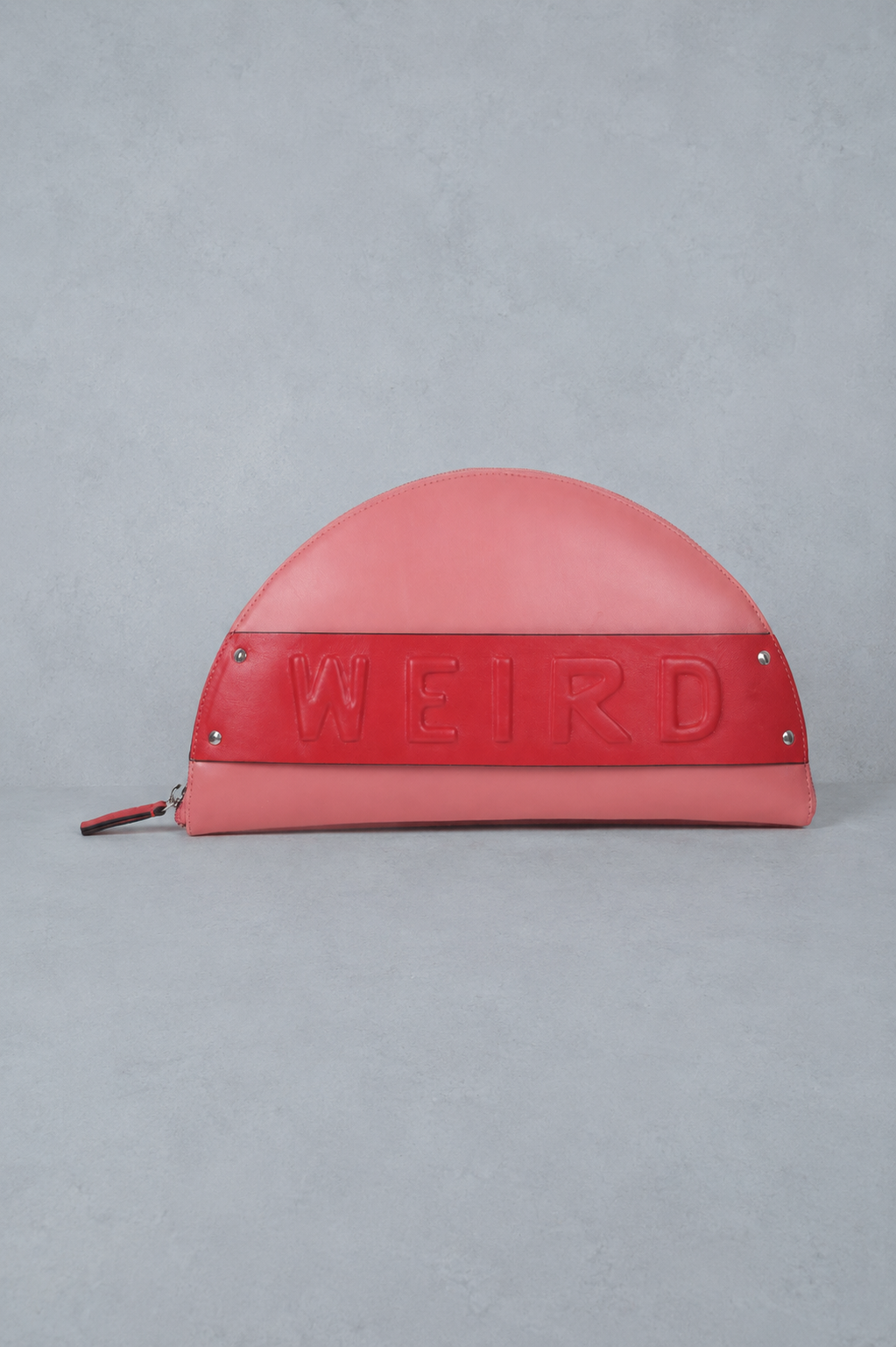 Red half-moon shaped pouch with 'WEIRD' text on a gray background