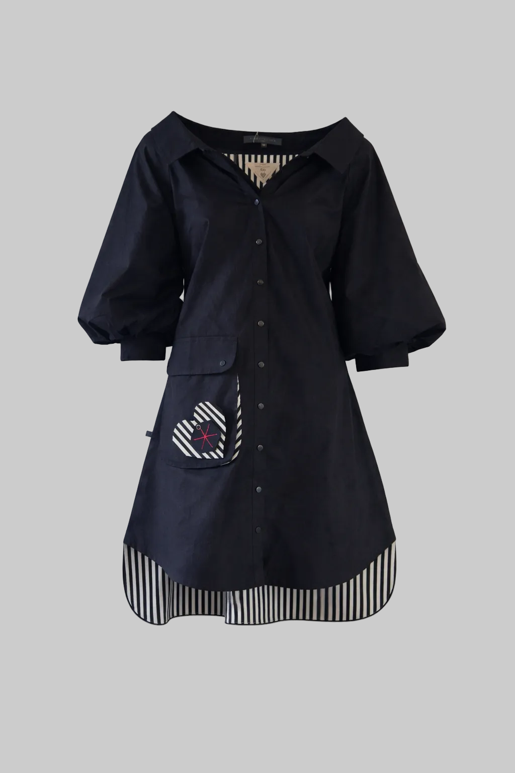 Black shirt with striped hem and pocket on a light gray background