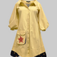 Yellow shirt dress with a red star patch on a light gray background