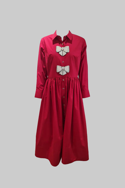 Red dress with white bow details on a gray background