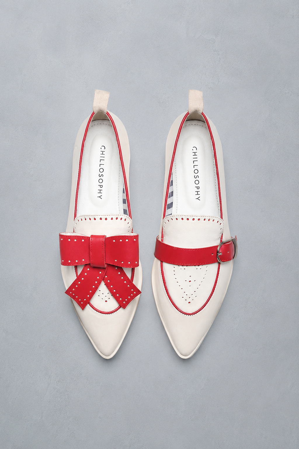 White shoes with red bows and straps on a gray background