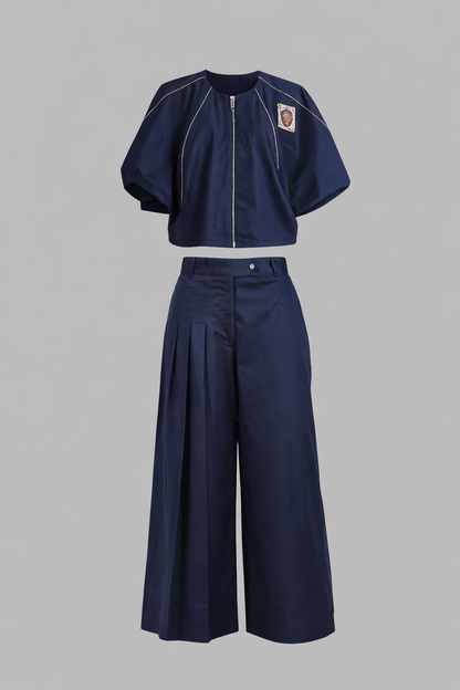 Navy blue outfit with a cropped jacket and wide-leg pants on a gray background