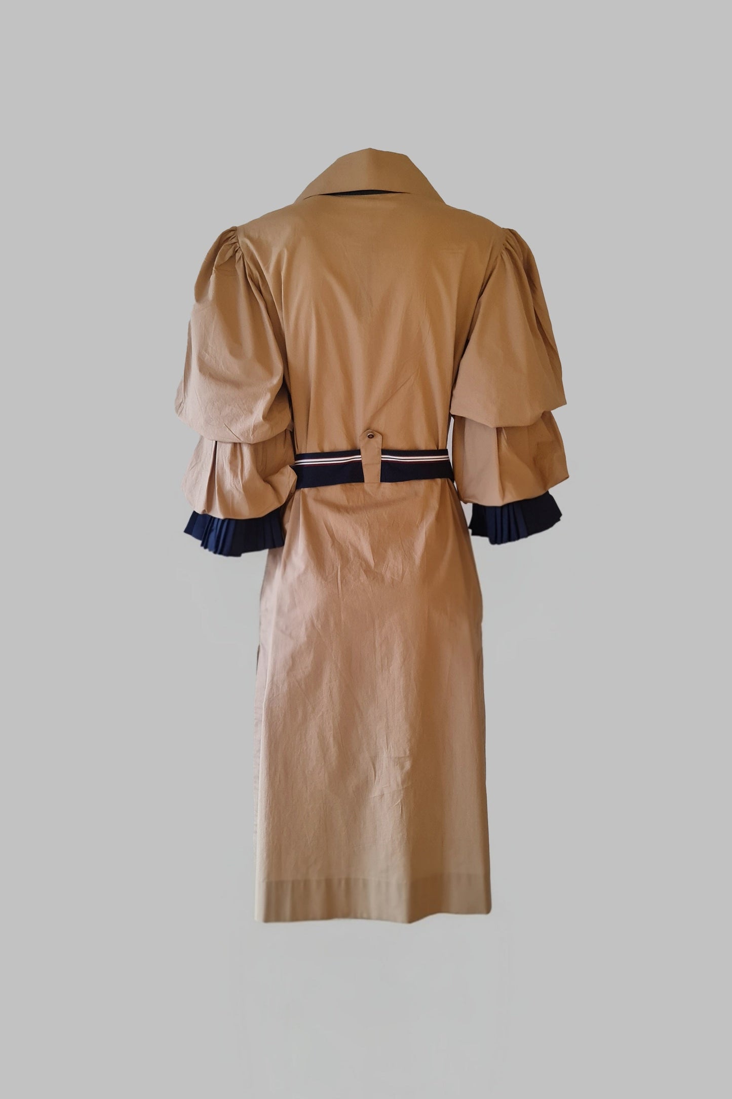 Tan trench coat with puff sleeves on a gray background